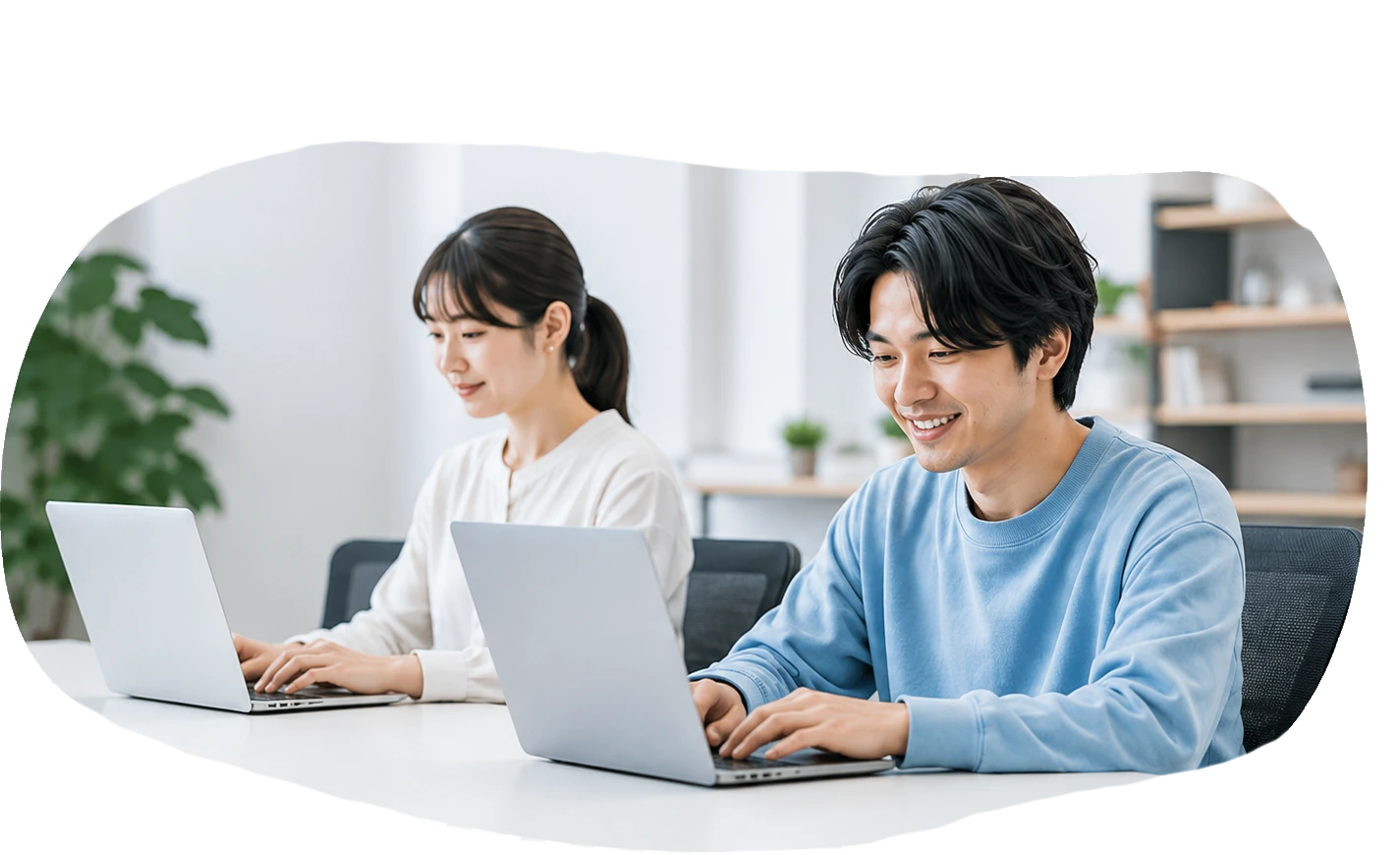 明るい施設内でパソコンを使って訓練する利用者
